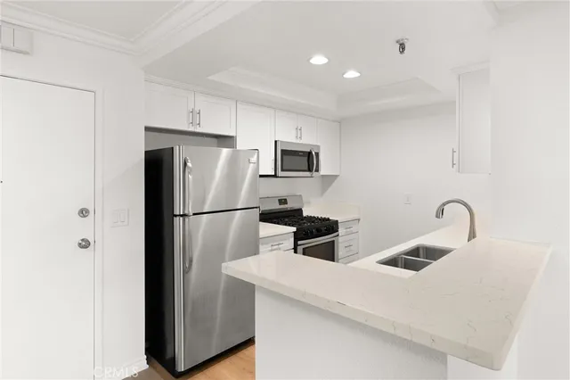 a kitchen with stainless steel appliances a refrigerator stove microwave and sink