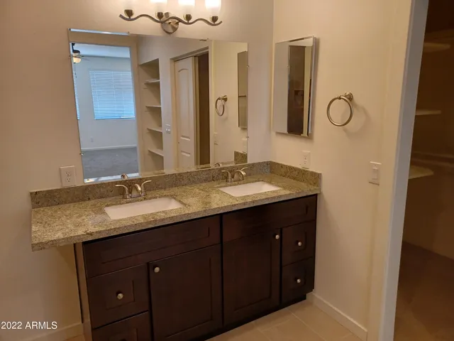 a bathroom with a granite countertop sink and a mirror
