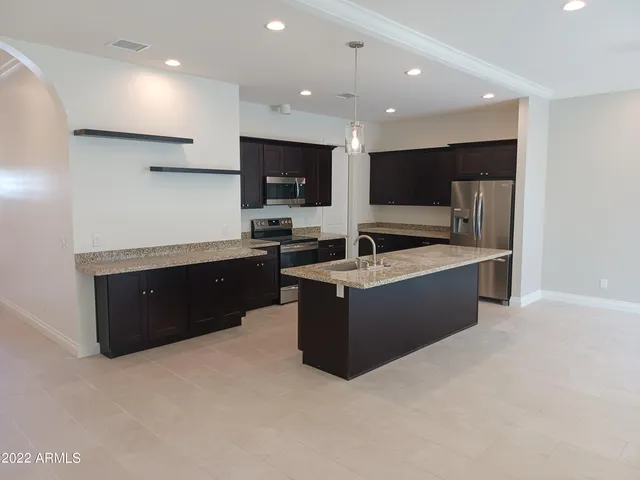 a large kitchen with a large counter top and stainless steel appliances