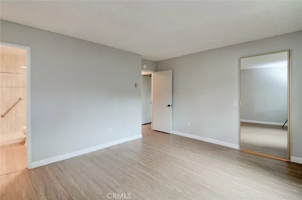 an empty room with wooden floor & windows