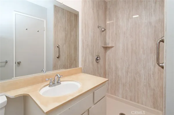 a bathroom with a sink vanity granite tub shower and a mirror