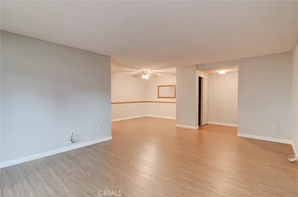 a view of a big room with wooden floor and windows