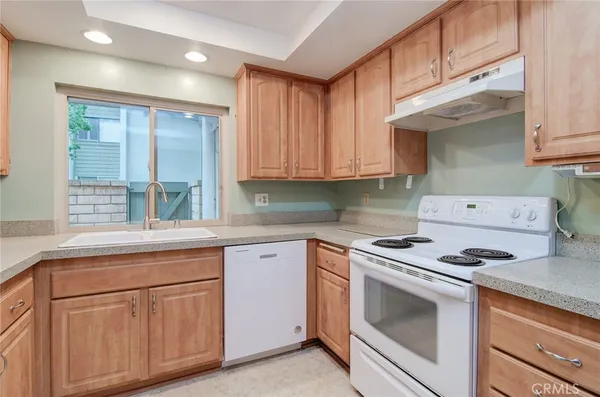 a kitchen with white cabinets and white appliances
