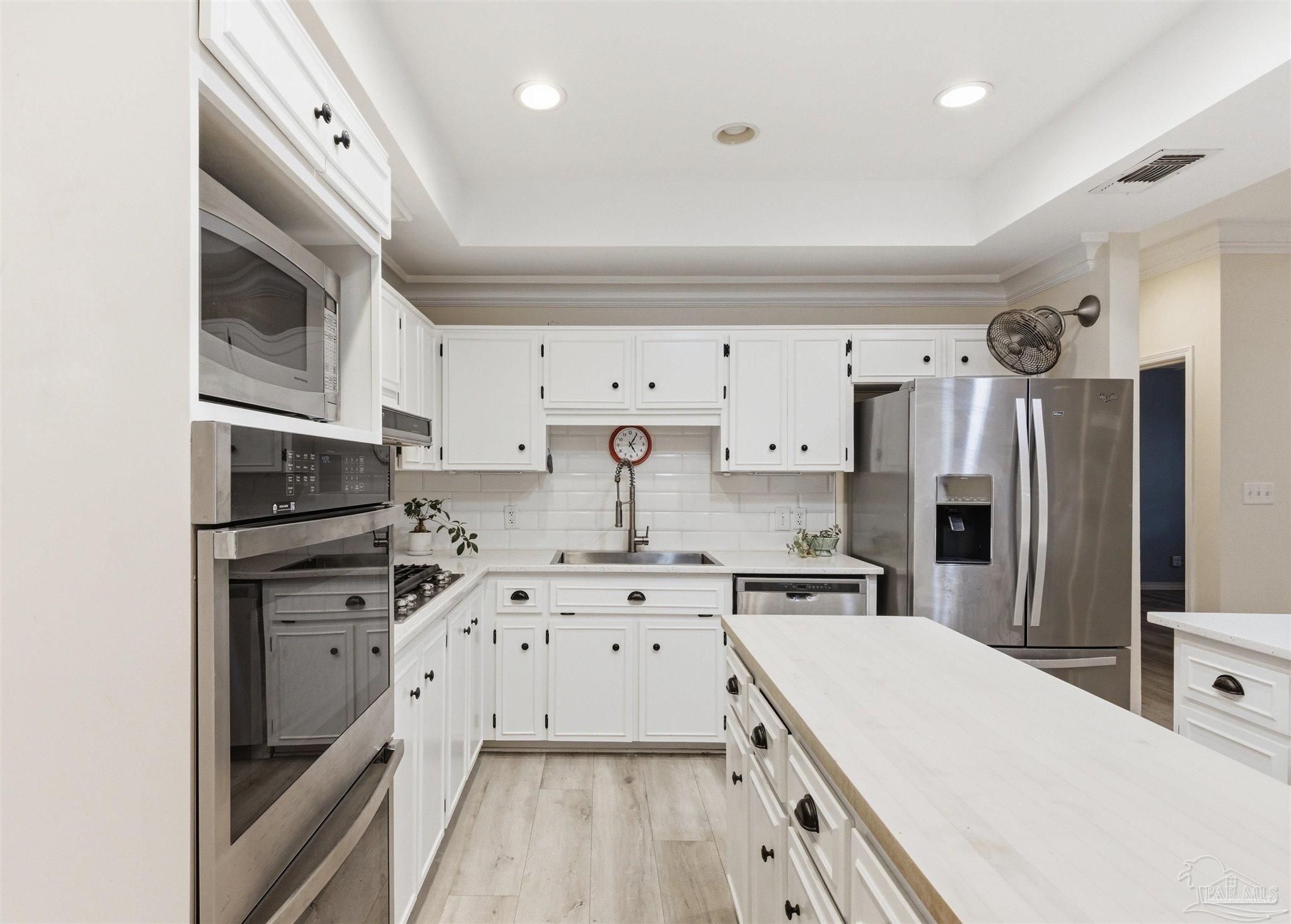 2437 West Bayshore Road Gulf Breeze, FL 32563 - Photo 20 of 62 a kitchen with cabinets and stainless steel appliances
