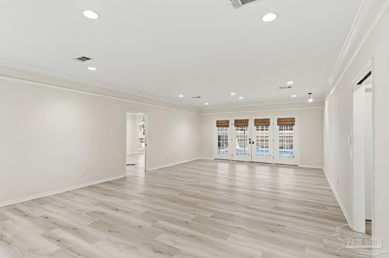 2437 West Bayshore Road Gulf Breeze, FL 32563 - Photo 3 of 62 an empty room with wooden floor and windows