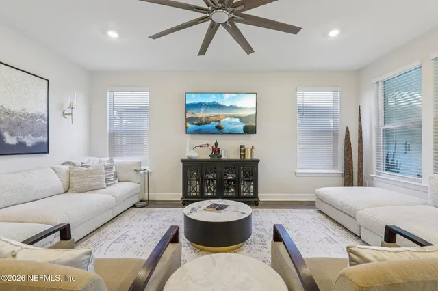 a dining room with furniture a large window and wooden floor