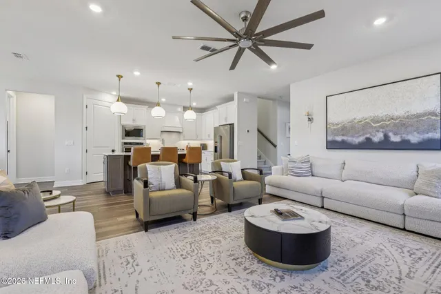 a dining room with wooden floor a chandelier a wooden table and chairs