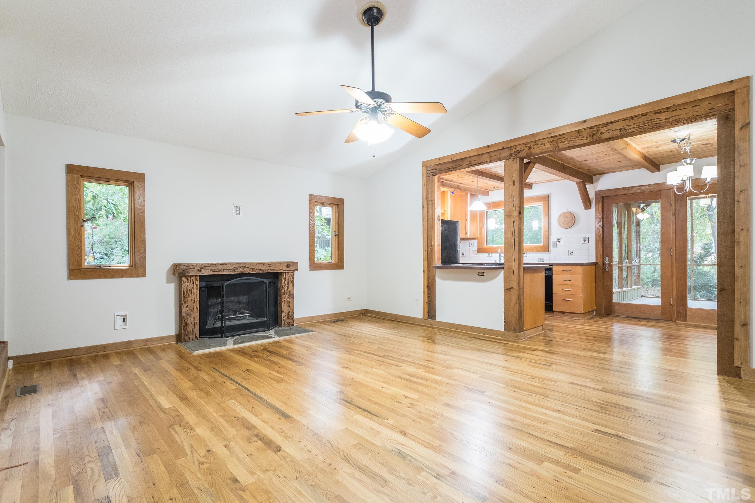 504 Merrie Road Raleigh, NC 27606 - Photo 11 of 25 a view of an empty room with a fireplace and wooden floor