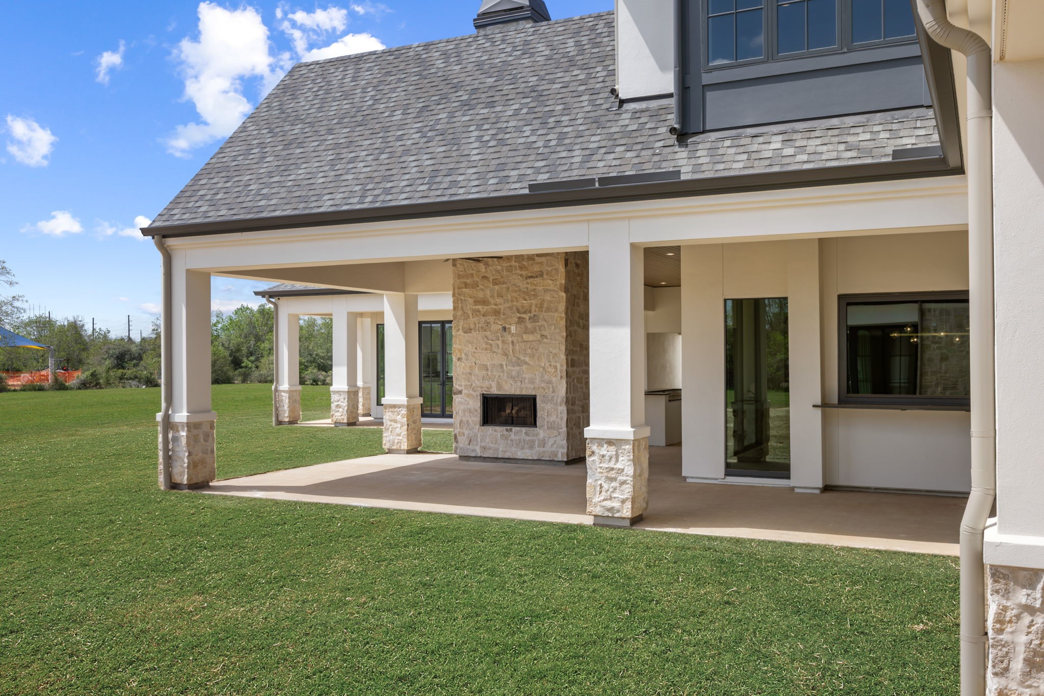4233 Two Gun Way Katy, TX 77494 - Photo 45 of 47 View of rear loggia with fireplace and sitting area. That is the serving vindow that opens awning style from the bar in the game room.