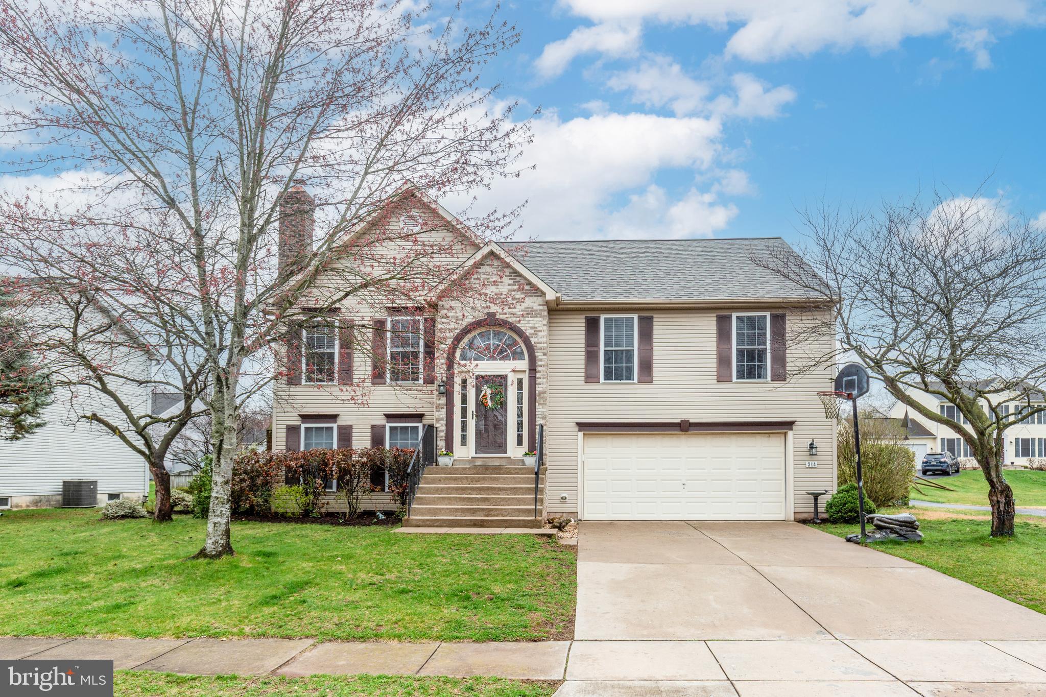 314 Huntinghorn Street Taneytown, MD 21787 - Photo 1 of 47 a front view of a house with a garden and trees