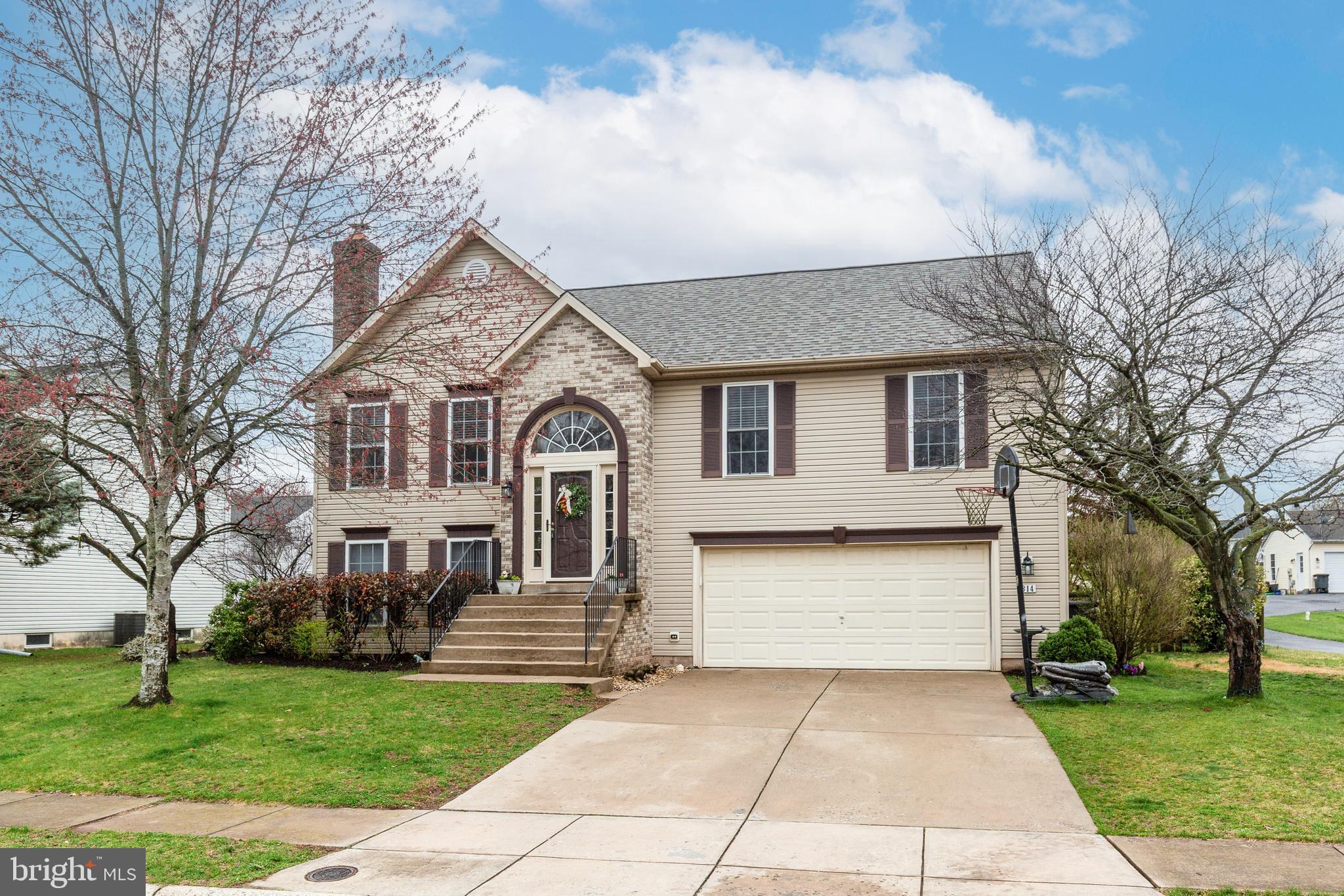 314 Huntinghorn Street Taneytown, MD 21787 - Photo 2 of 47 a front view of a house with a garden and trees
