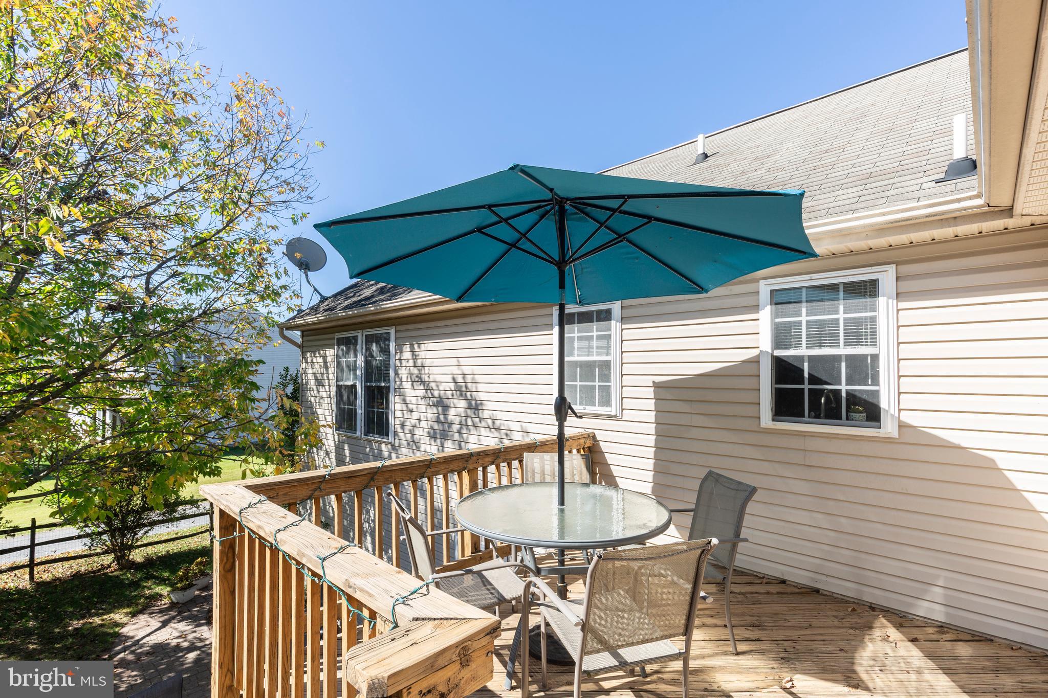 314 Huntinghorn Street Taneytown, MD 21787 - Photo 45 of 47 a deck with a table and chairs under an umbrella