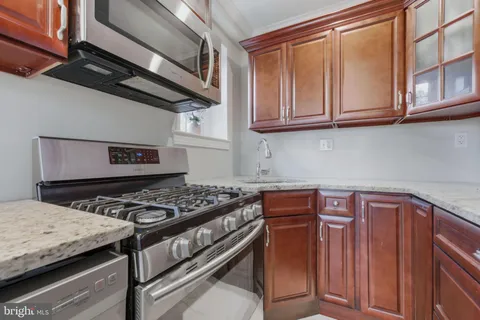 a kitchen with stainless steel appliances granite countertop a stove and a sink