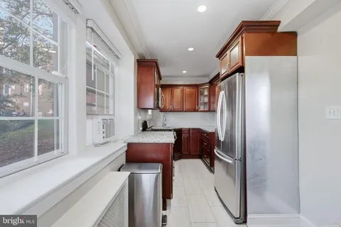 a kitchen with stainless steel appliances granite countertop a refrigerator and a cabinets