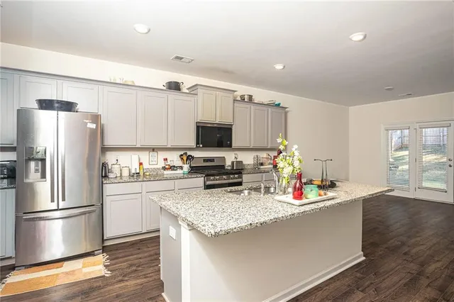 a kitchen with stainless steel appliances granite countertop a sink stove and cabinets