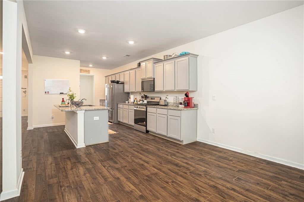 5381 Flat Rock Point Stonecrest, GA 30038 - Photo 27 of 53 a kitchen with stainless steel appliances a white stove top oven cabinets and a wooden floor