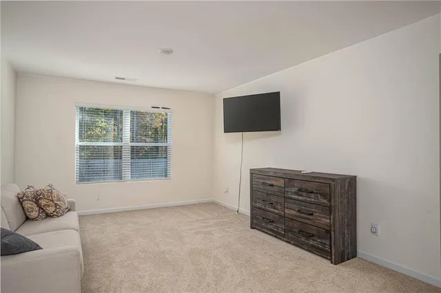 a view of room with wooden floor and flat screen tv