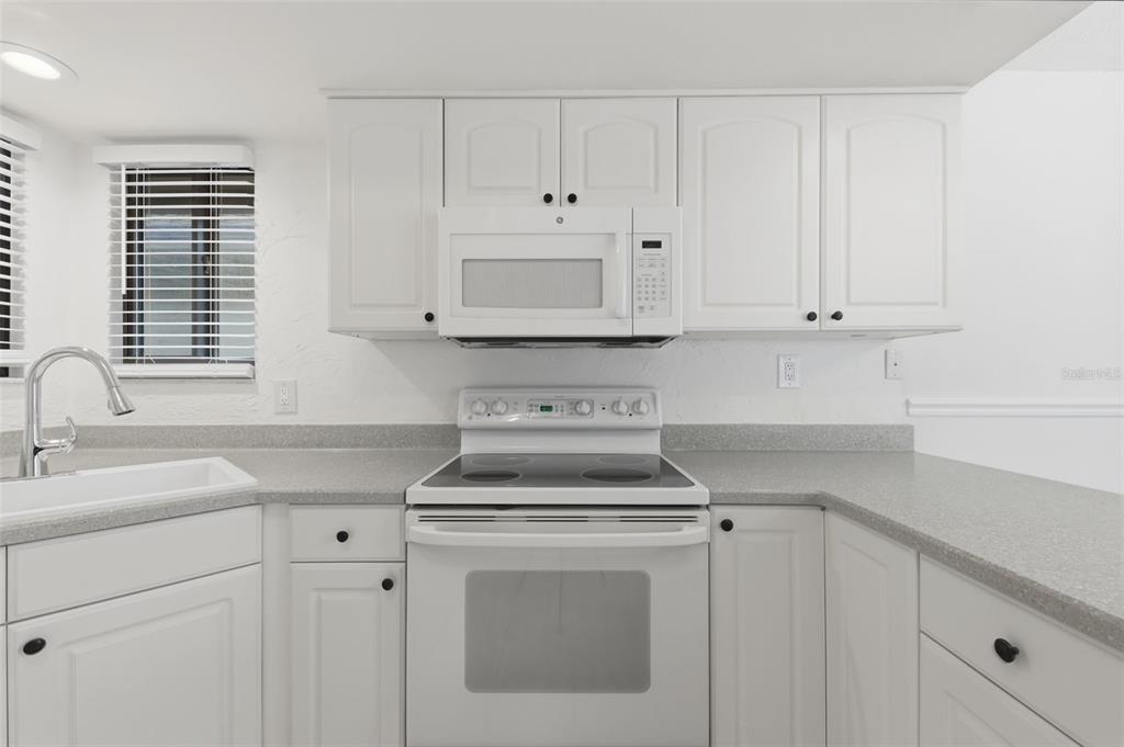 141 Spring Wind Way Casselberry, FL 32707 - Photo 16 of 32 a kitchen with white cabinets and white appliances