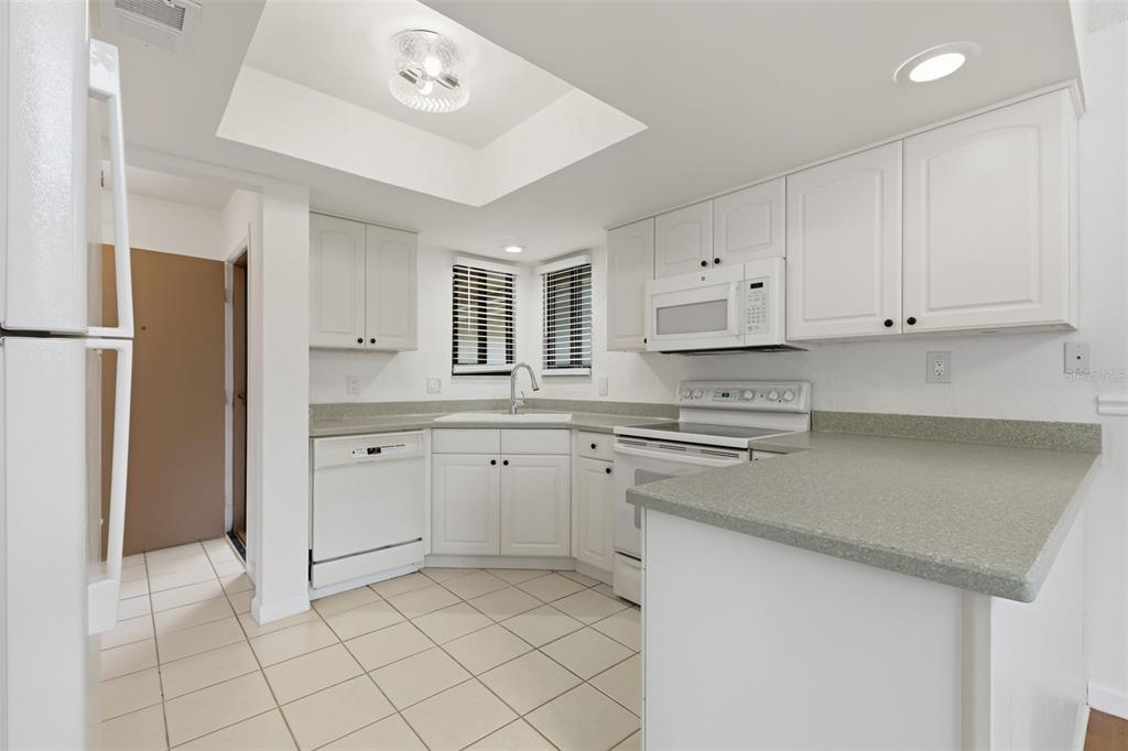 141 Spring Wind Way Casselberry, FL 32707 - Photo 8 of 32 a kitchen with white cabinets and white appliances