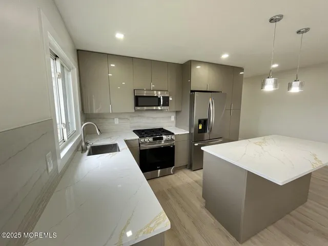 a kitchen with a refrigerator a stove top oven a sink dishwasher and wooden cabinets