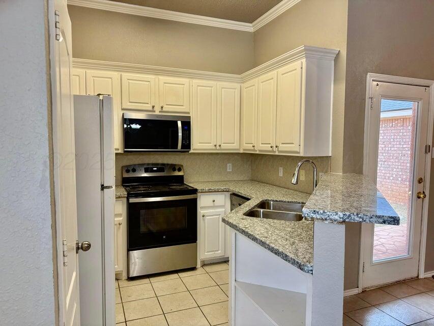 1918 75th Street Lubbock, TX 79423 - Photo 7 of 15 a kitchen with granite countertop a stove and a refrigerator
