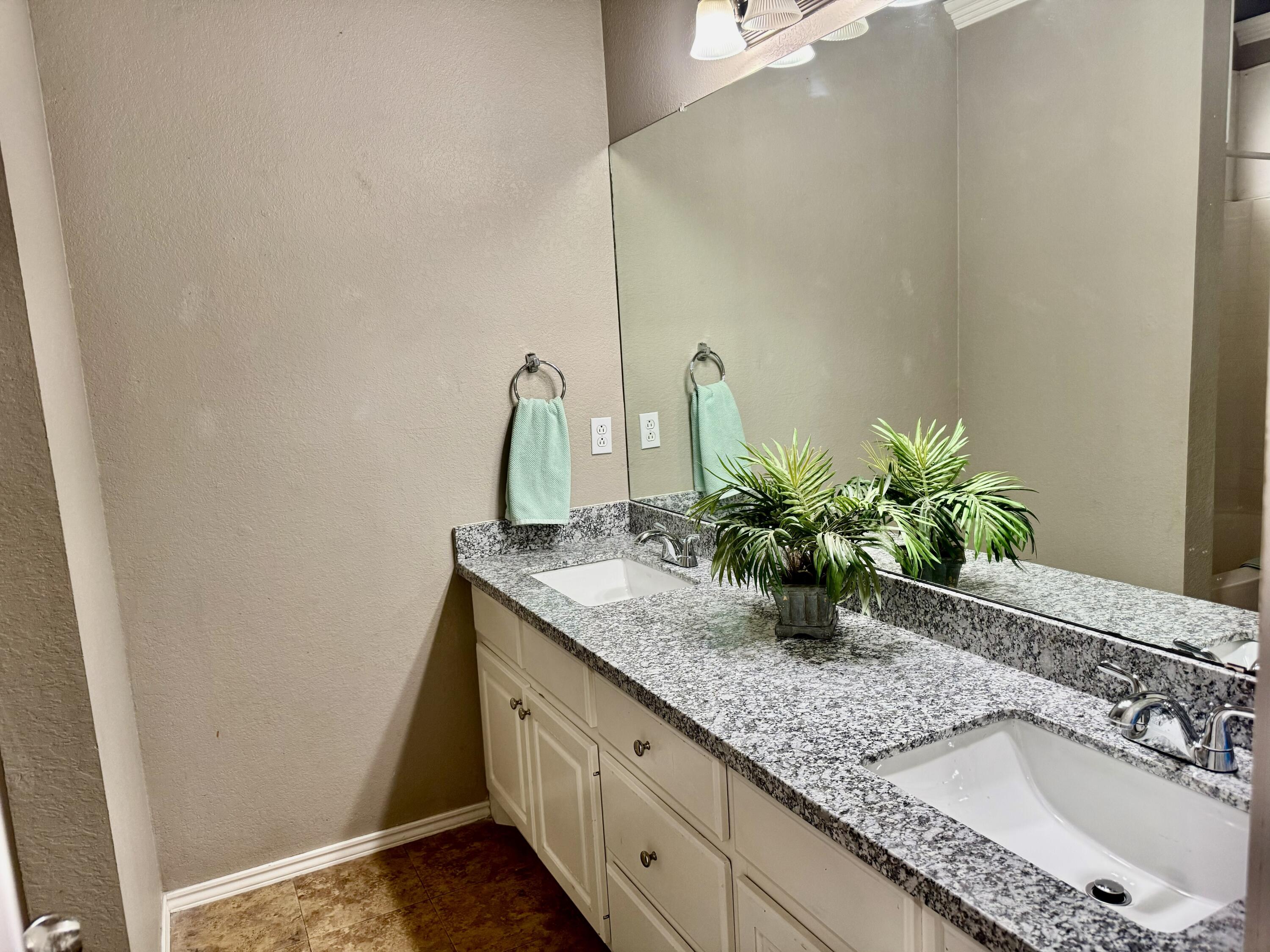 1918 75th Street Lubbock, TX 79423 - Photo 7 of 15 a bathroom with a granite countertop sink and a mirror