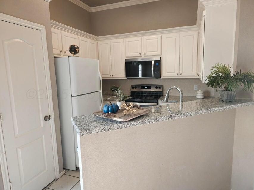 1918 75th Street Lubbock, TX 79423 - Photo 8 of 15 a kitchen with stainless steel appliances granite countertop a refrigerator a stove a sink a microwave and cabinets