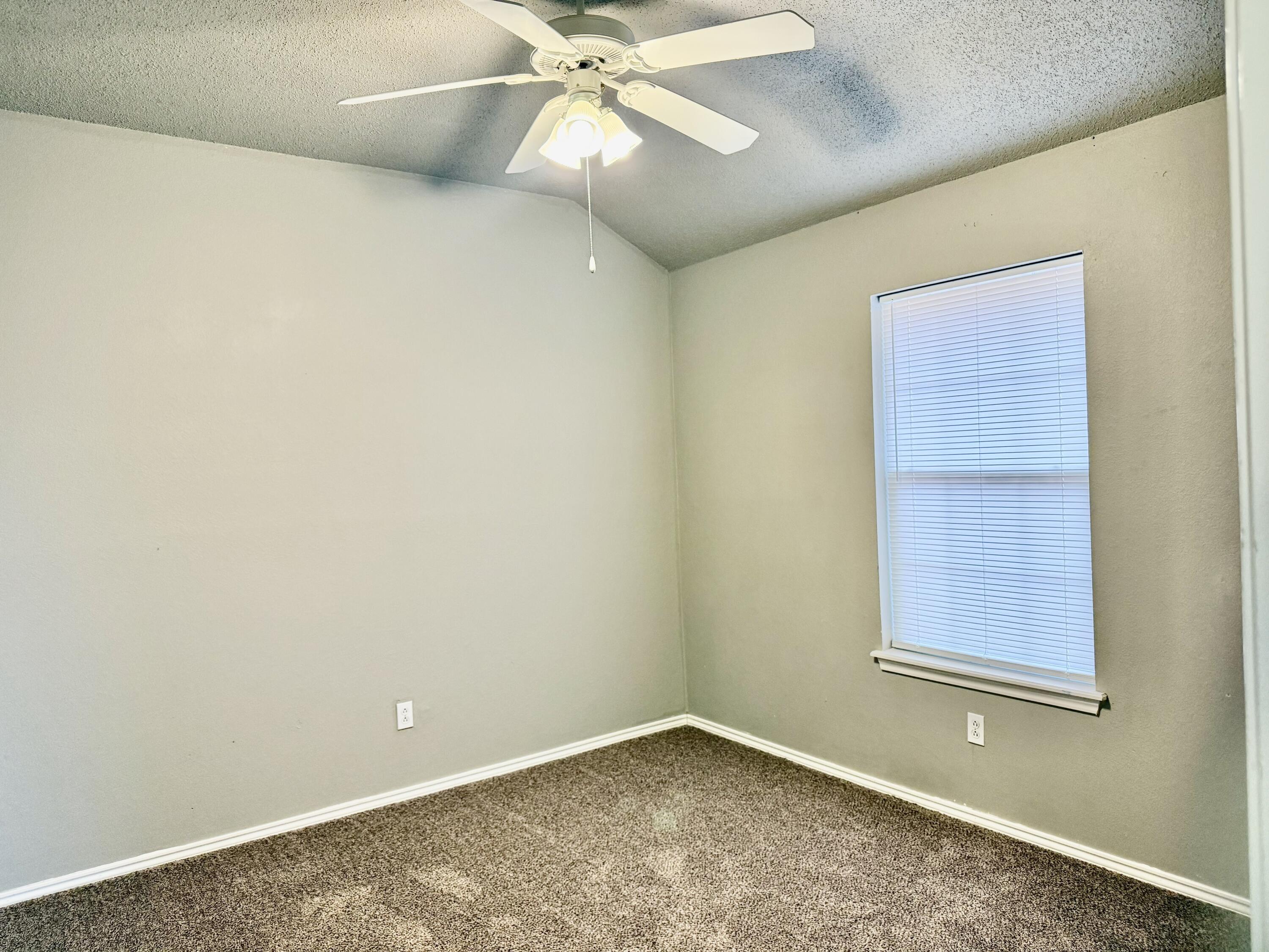 1918 75th Street Lubbock, TX 79423 - Photo 9 of 15 an empty room with a fan & a window
