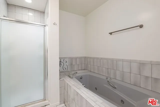 a bathroom with a tub a sink and a shower
