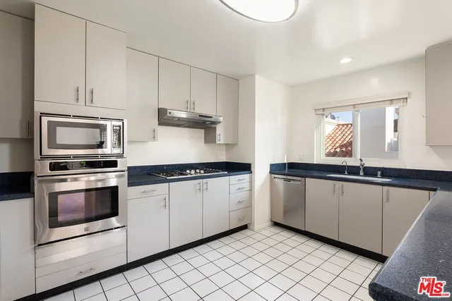 a kitchen with stainless steel appliances granite countertop a stove and a microwave