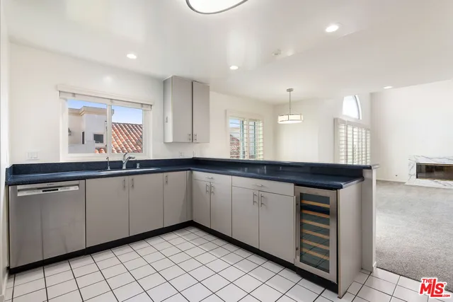 a large white kitchen with a sink and dishwasher