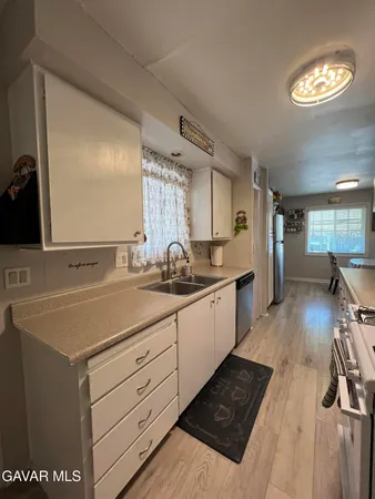 a large kitchen with stainless steel appliances granite countertop a lot of counter space and wooden floors