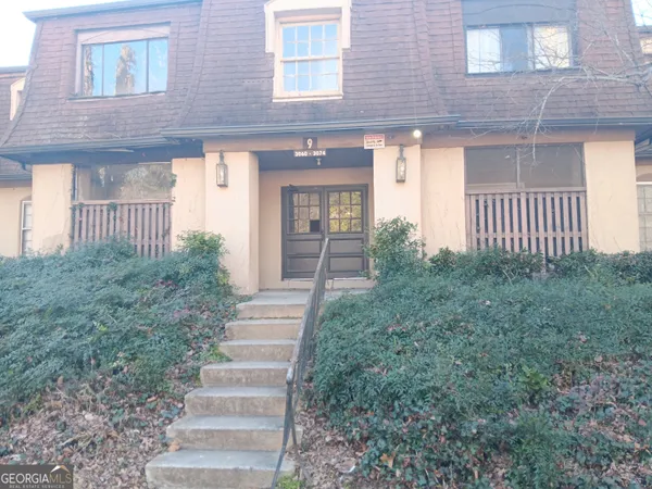 a view of a house with brick walls and a yard