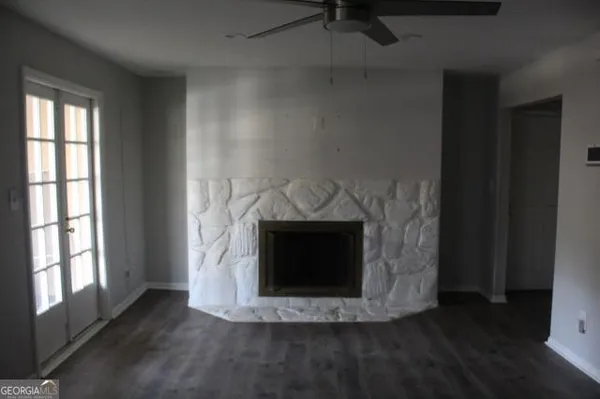 a view of fireplace and a room with wooden floor