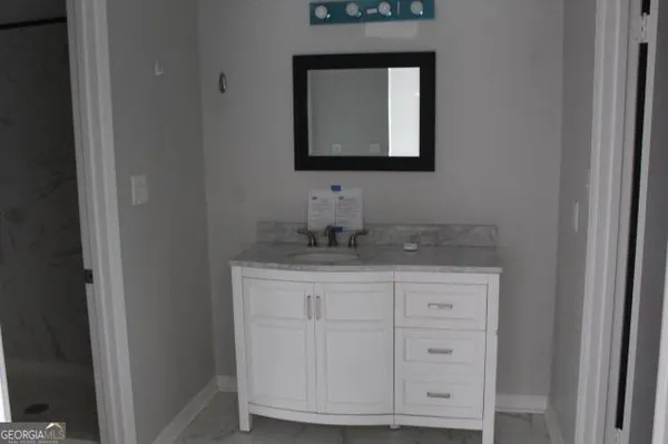 a bathroom with a sink vanity and mirror