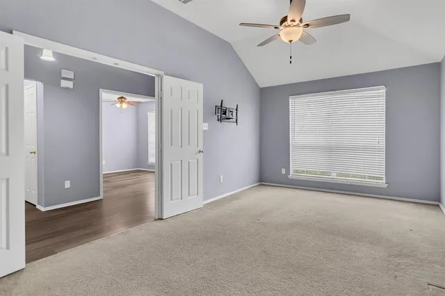 an empty room with fan and windows