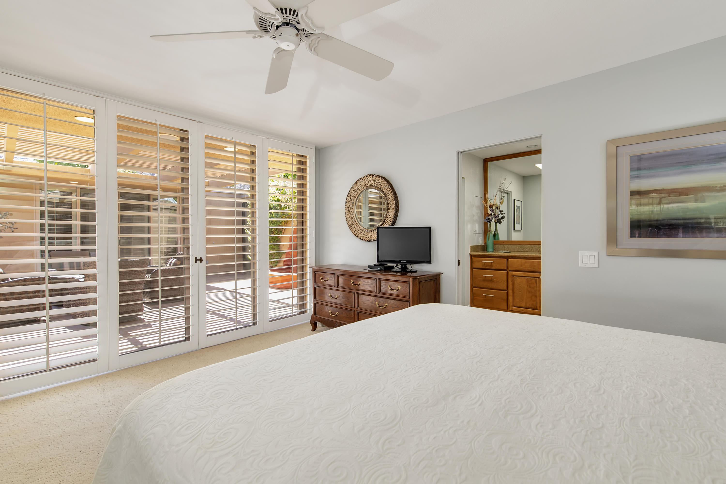 77920 Cherokee Road Indian Wells, CA 92210 - Photo 22 of 39 a bedroom with a large bed and a chandelier