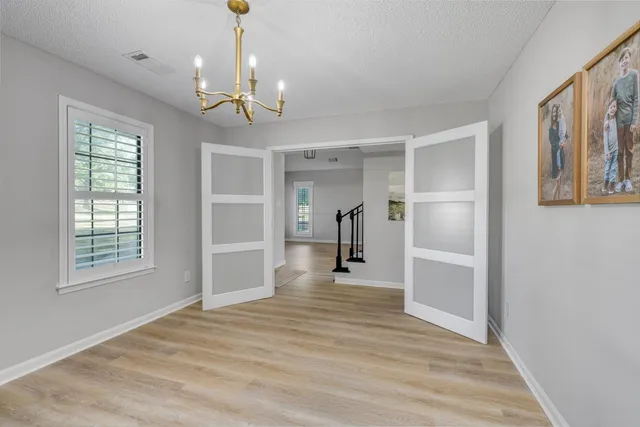 a view of empty room with wooden floor