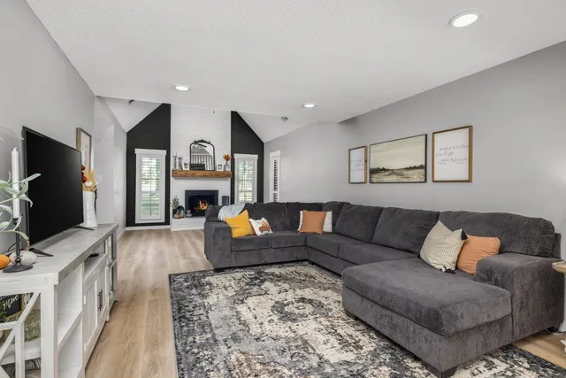 a living room with furniture a fireplace and a flat screen tv