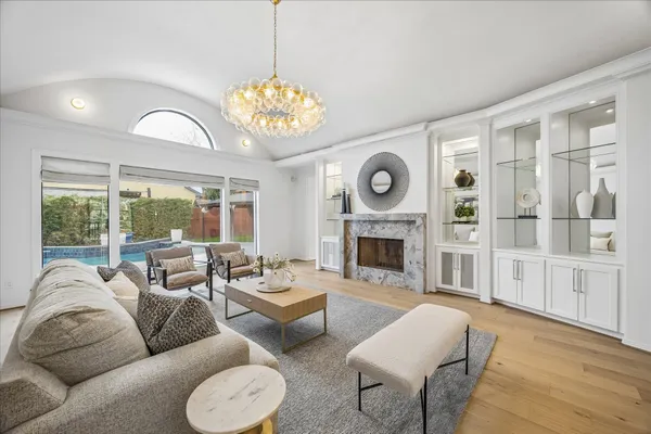 a living room with furniture a fireplace and a chandelier
