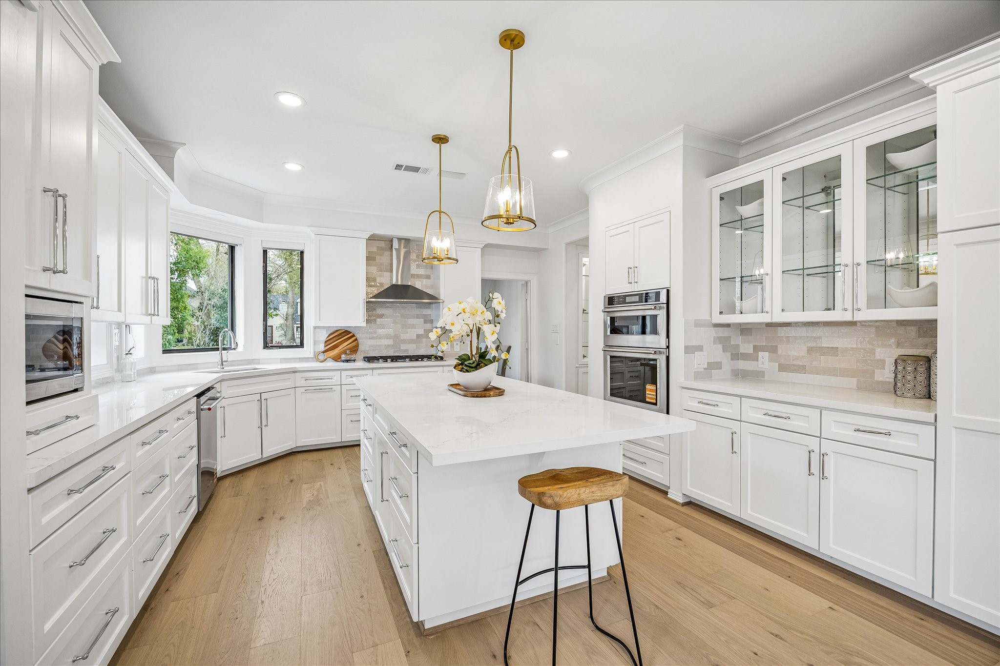 4614 Spruce Street Bellaire, TX 77401 - Photo 14 of 30 a kitchen with white cabinets and stainless steel appliances
