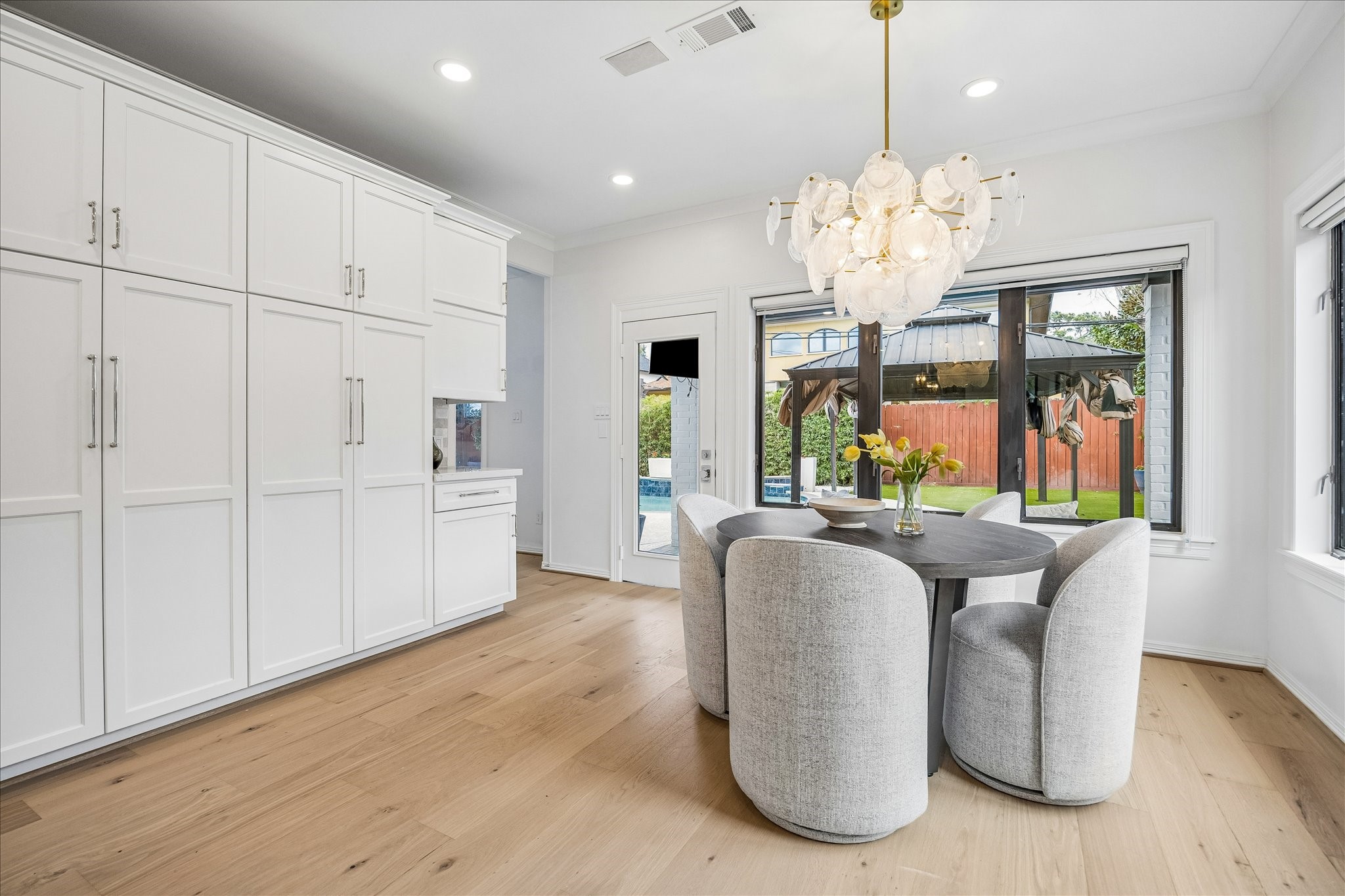 4614 Spruce Street Bellaire, TX 77401 - Photo 15 of 30 a dining room with furniture a chandelier and wooden floor