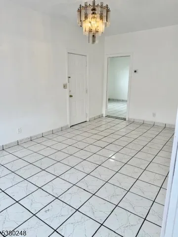 a view of a room with chandelier fan and wooden floor
