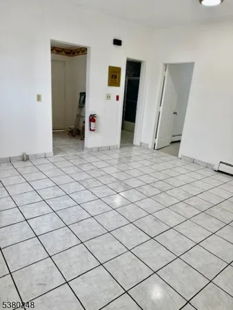 a view of a livingroom with washing machine and wooden floor