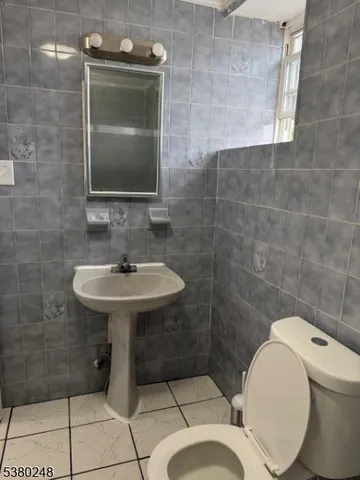 a bathroom with a sink toilet and mirror