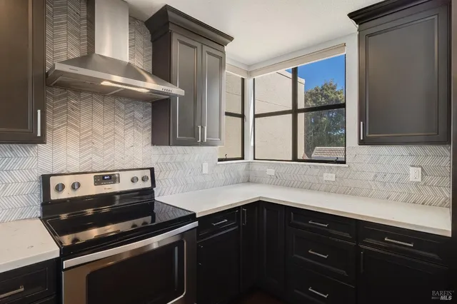 a kitchen island with granite countertop a sink and a stove with wooden floor