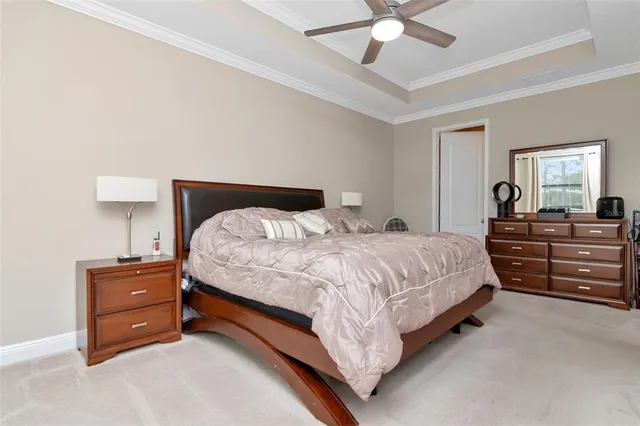 a spacious bedroom with a bed and a ceiling fan