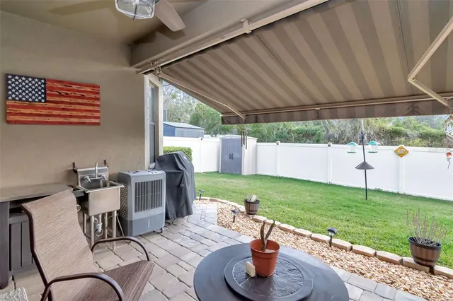 a view of a patio with a table chairs and a yard