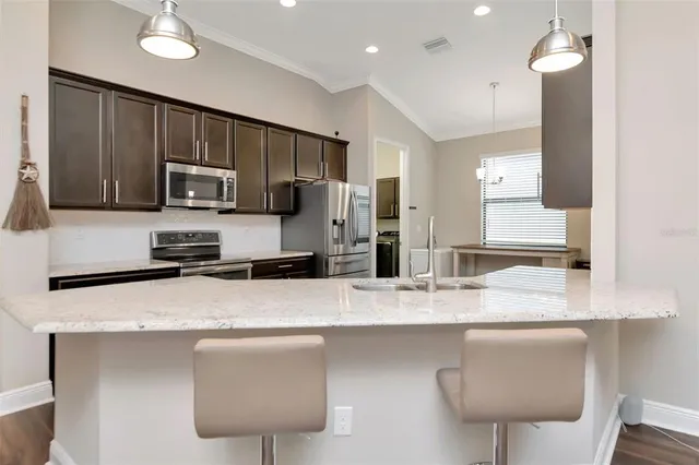 a kitchen with stainless steel appliances granite countertop a sink refrigerator and microwave