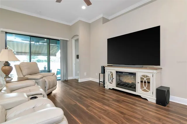 a living room with furniture a flat screen tv a window and a fireplace